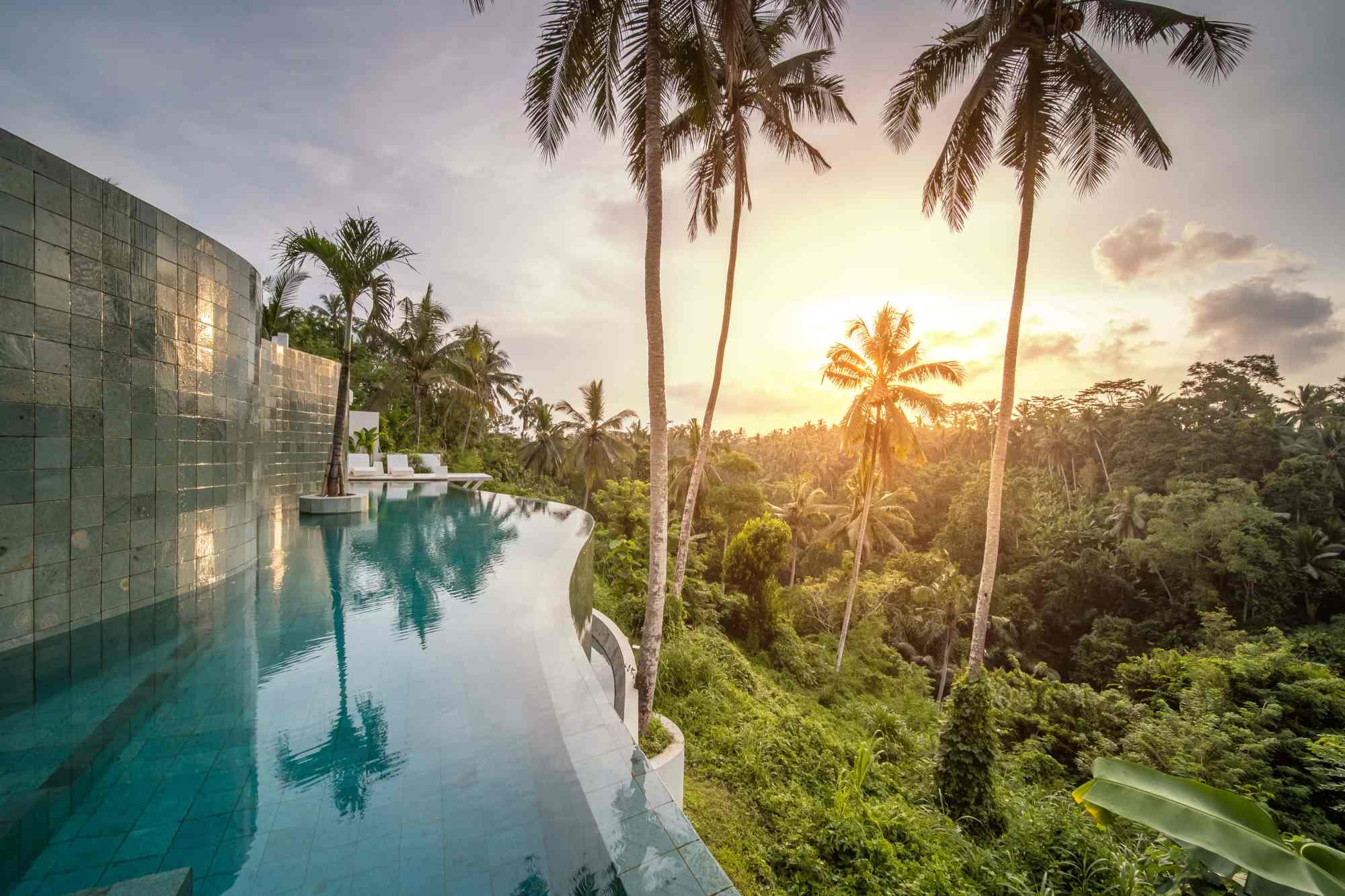 Infinity pool villa overlooking lush Bali jungle at golden hour
